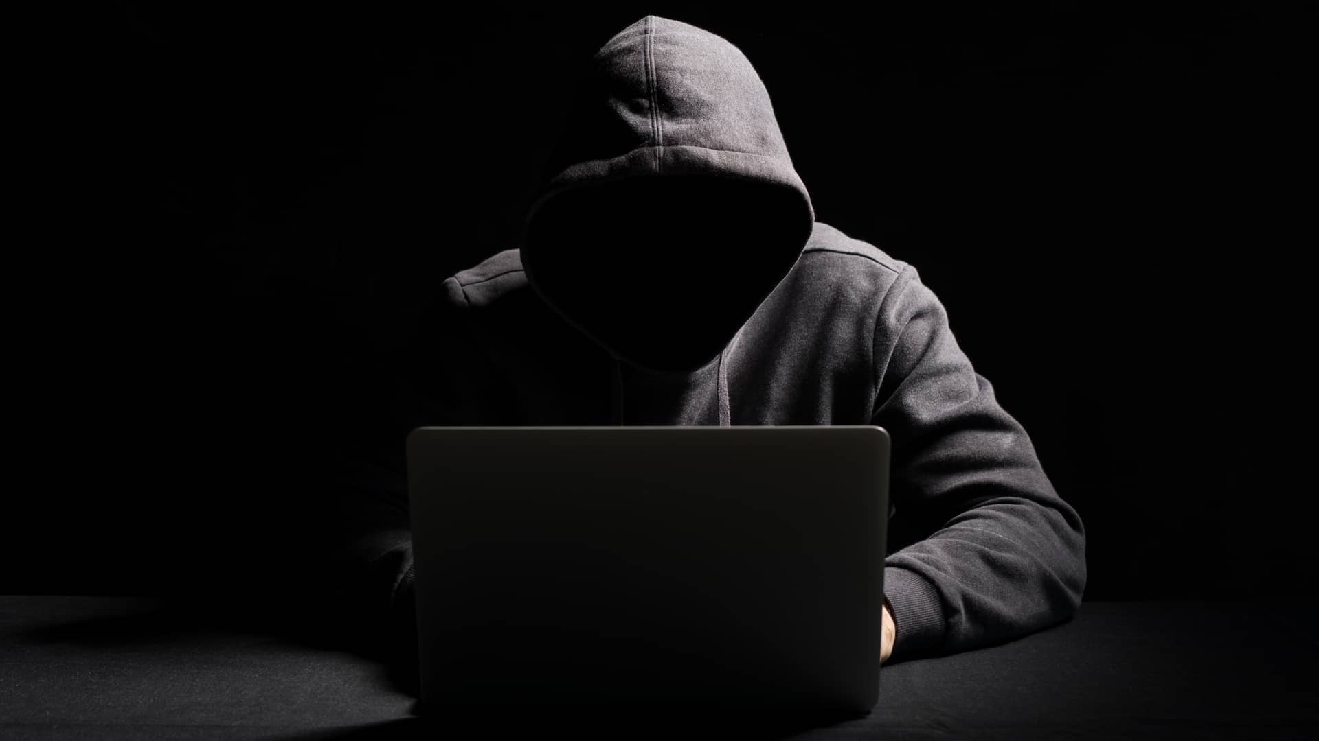 Hacker en la oscuridad tratando de robar criptomonedas