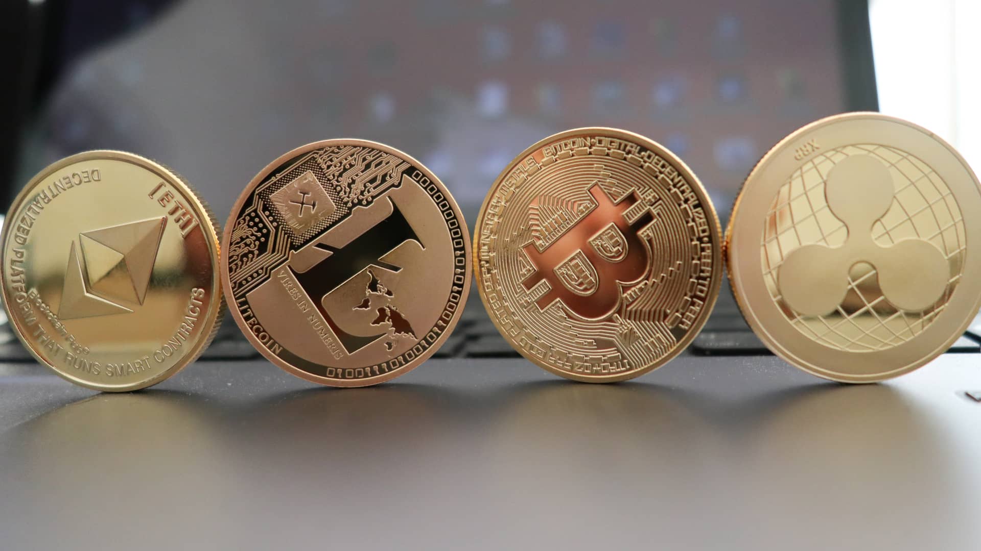 Cuatro monedas físicas de varias criptomonedas representa la posibilidad de intercambiarlas mediante uniswap