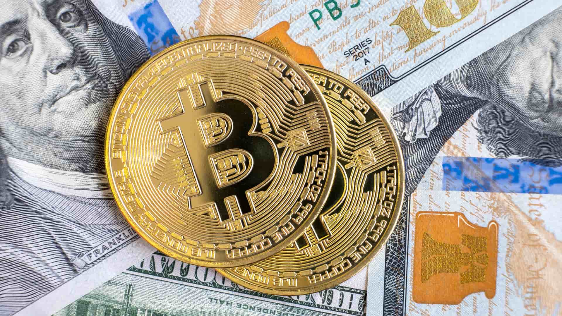 Dos monedas físicas de bitcoin sobre distintas divisas representa el valor potencial de las criptomonedas