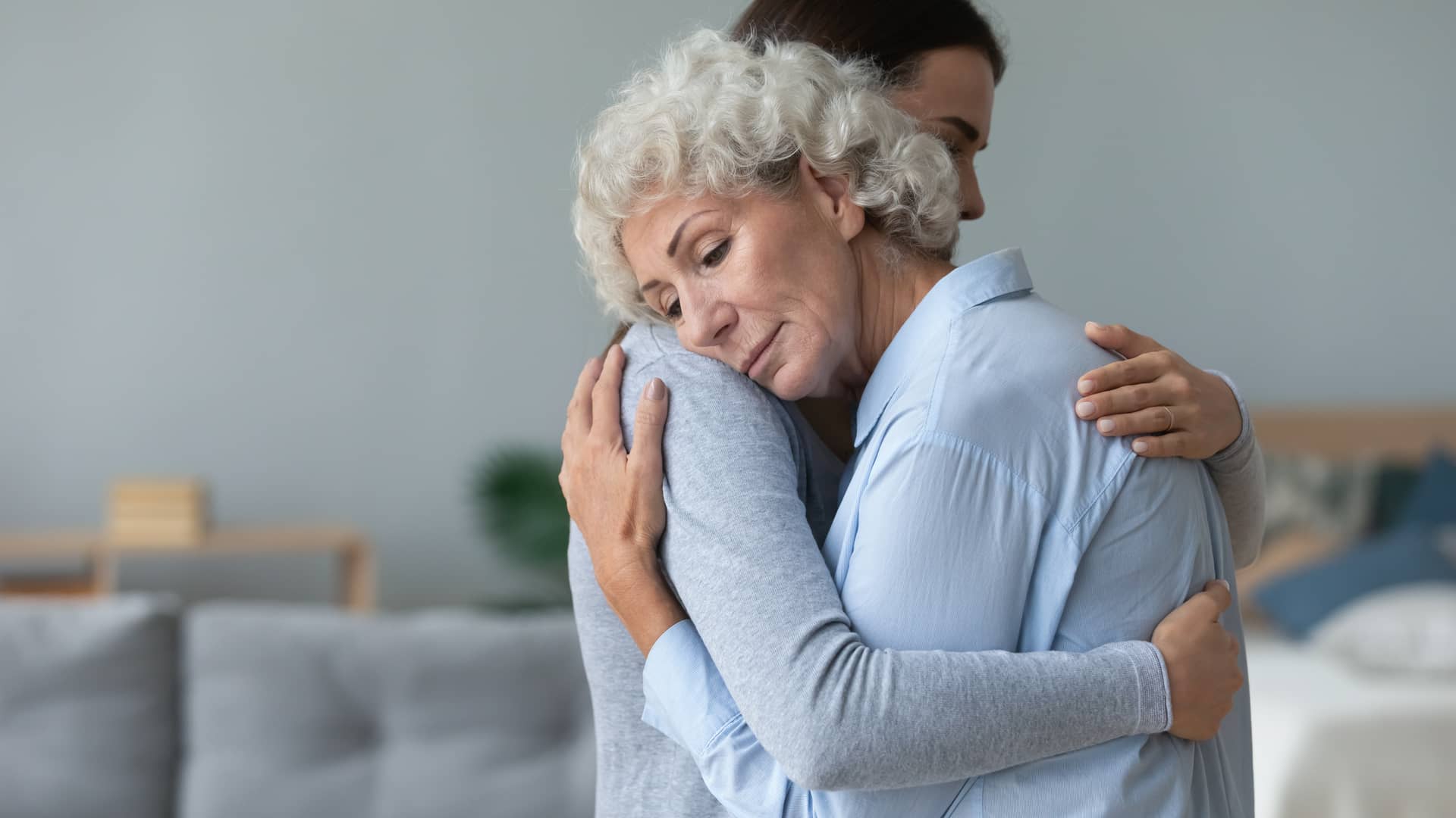 Mujer abrazando a su madre la cual recibira una pensión tras fallecimieto de su marido