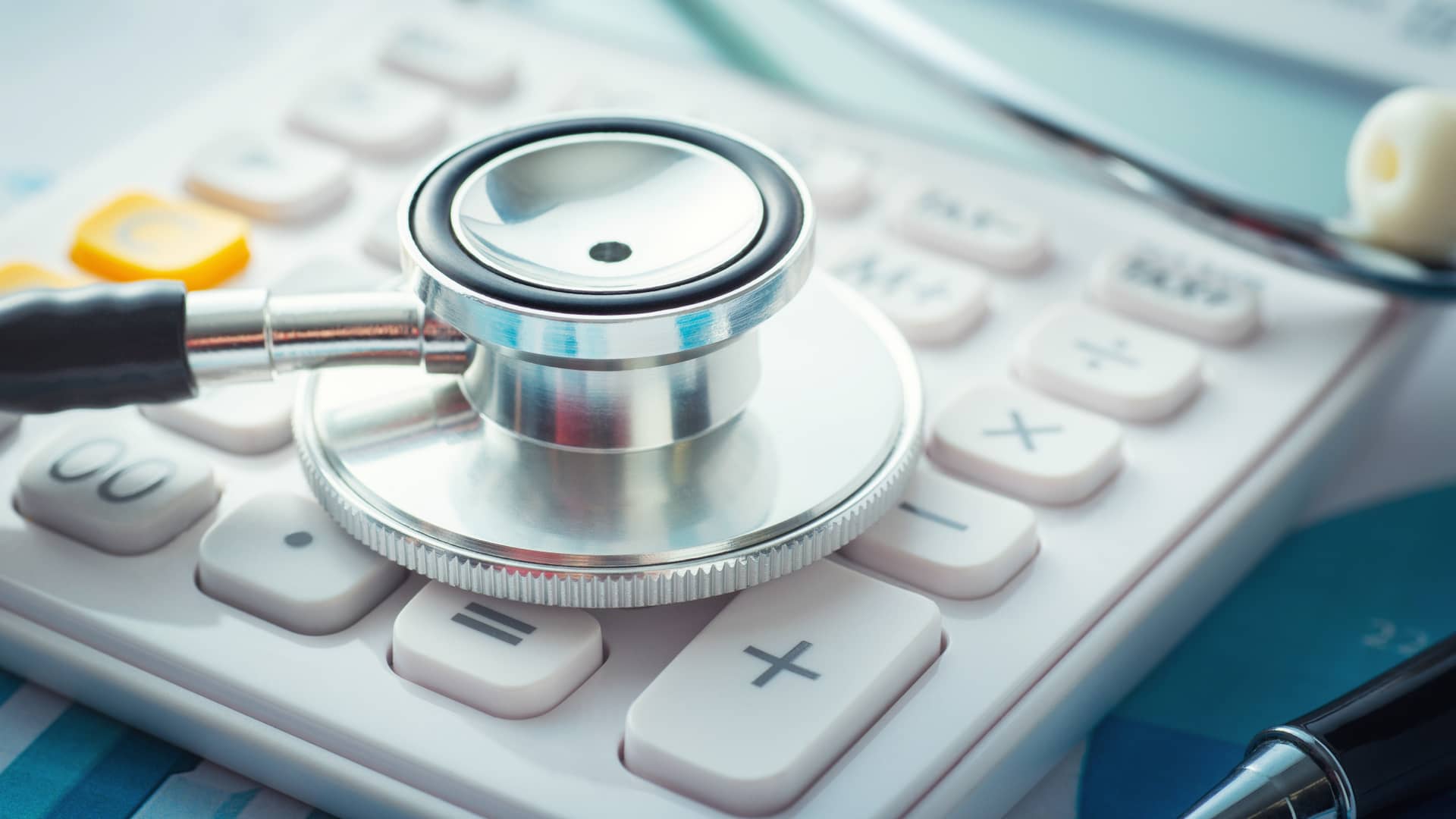 Detalle de estetoscopio sobre calculadora representa la existencia de crowdfundings con fines nobles como el pago de deudas médicas
