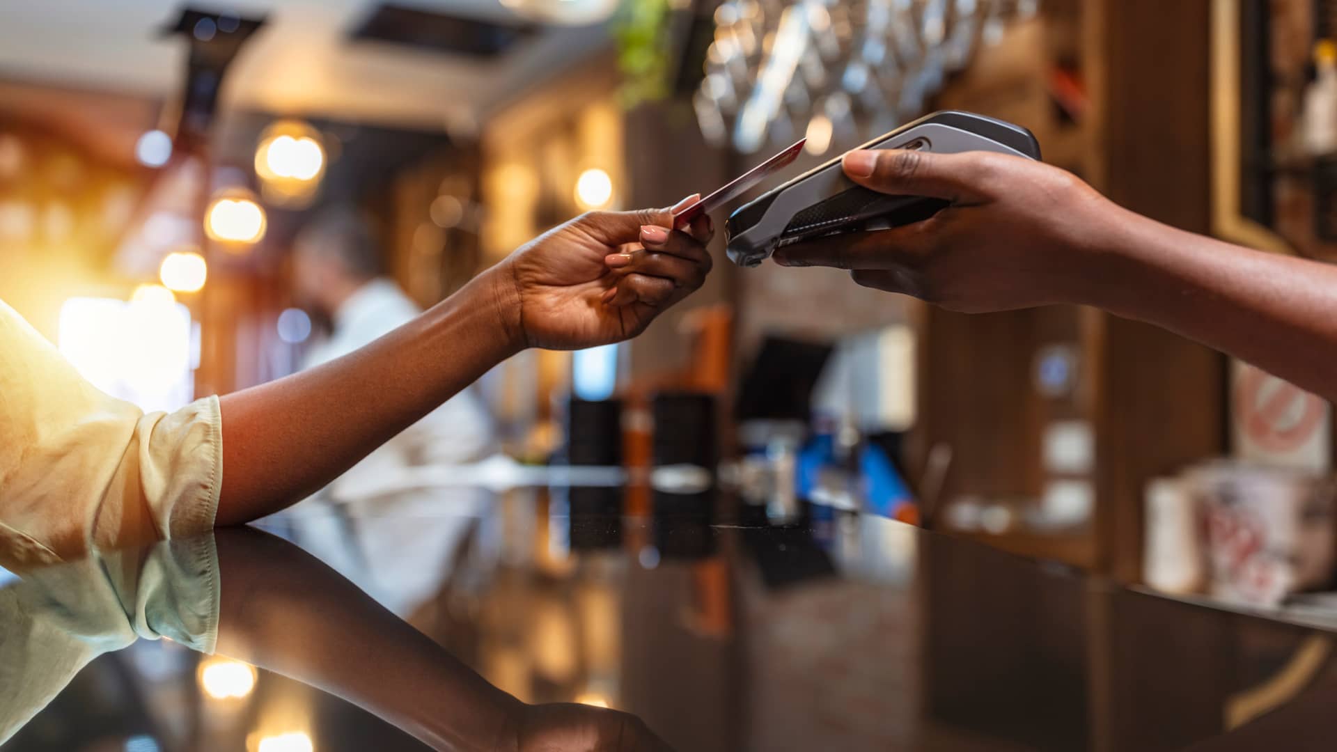 Mujer pagando en restaurante con tarjeta de crédito de la cuenta de ahorro de la empresa