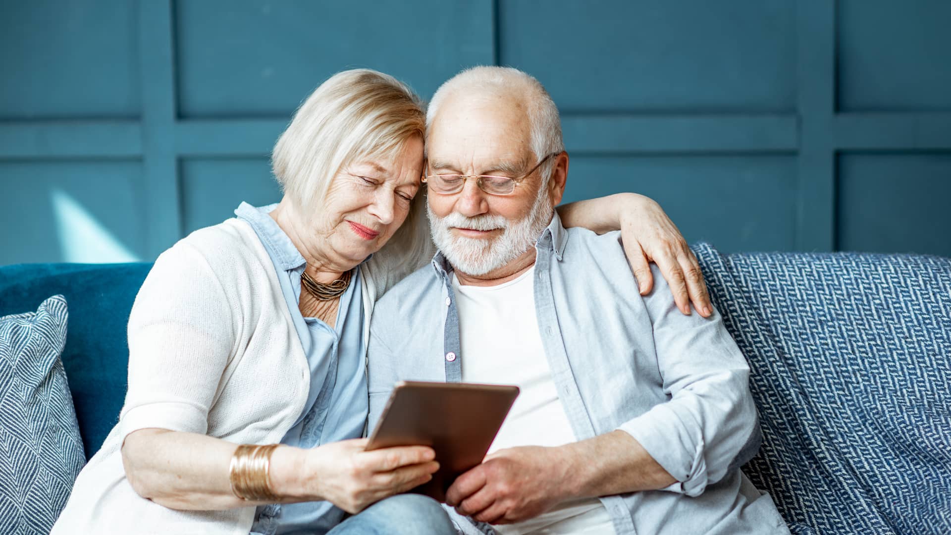 Pareja de jubilados planificando con su tablet su próximo viaje gracias a su plan de pensiones de bbva