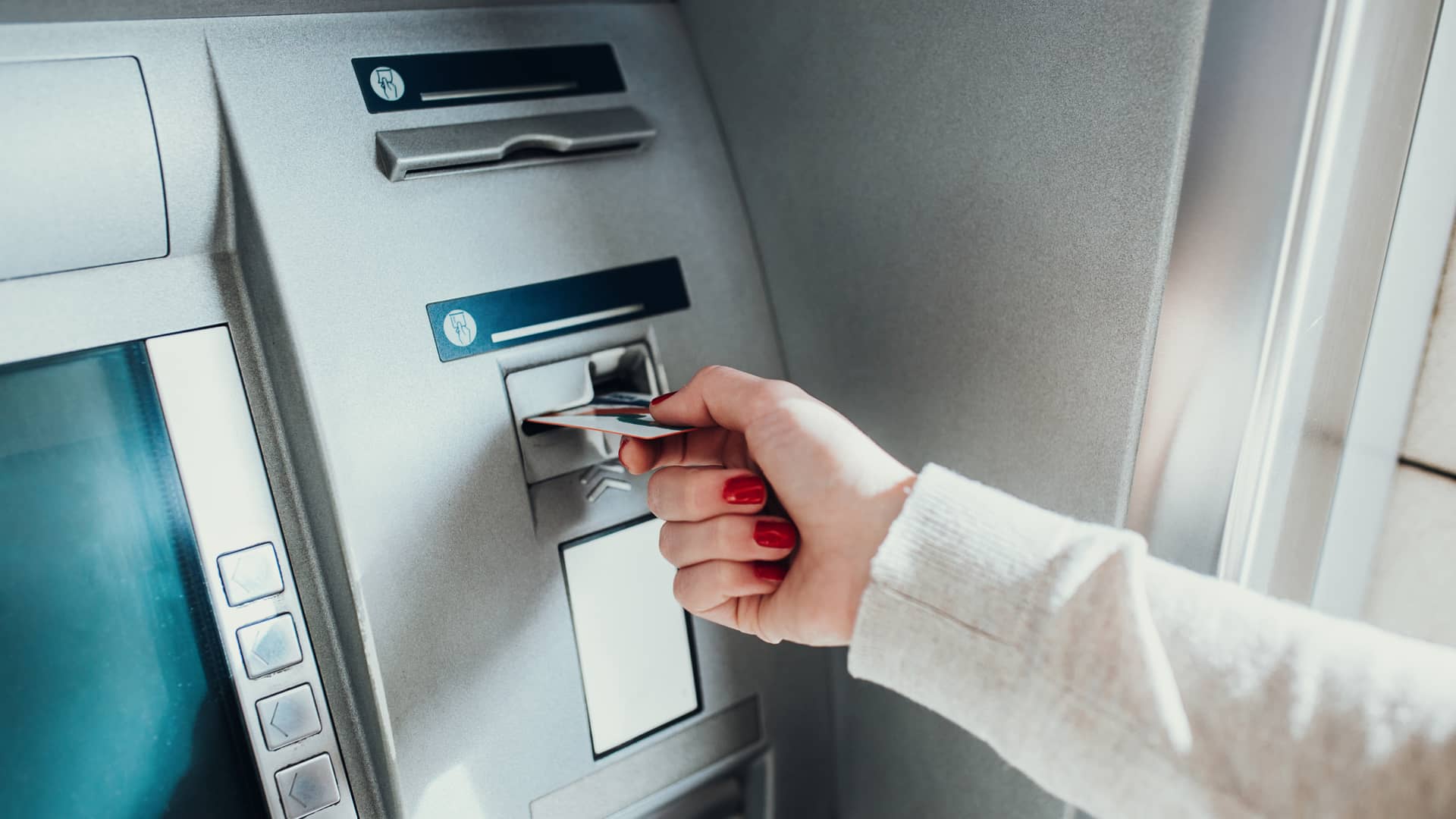 Mujer introduciendo tarjeta de crédito en cajero automático de oficinas de cajasur