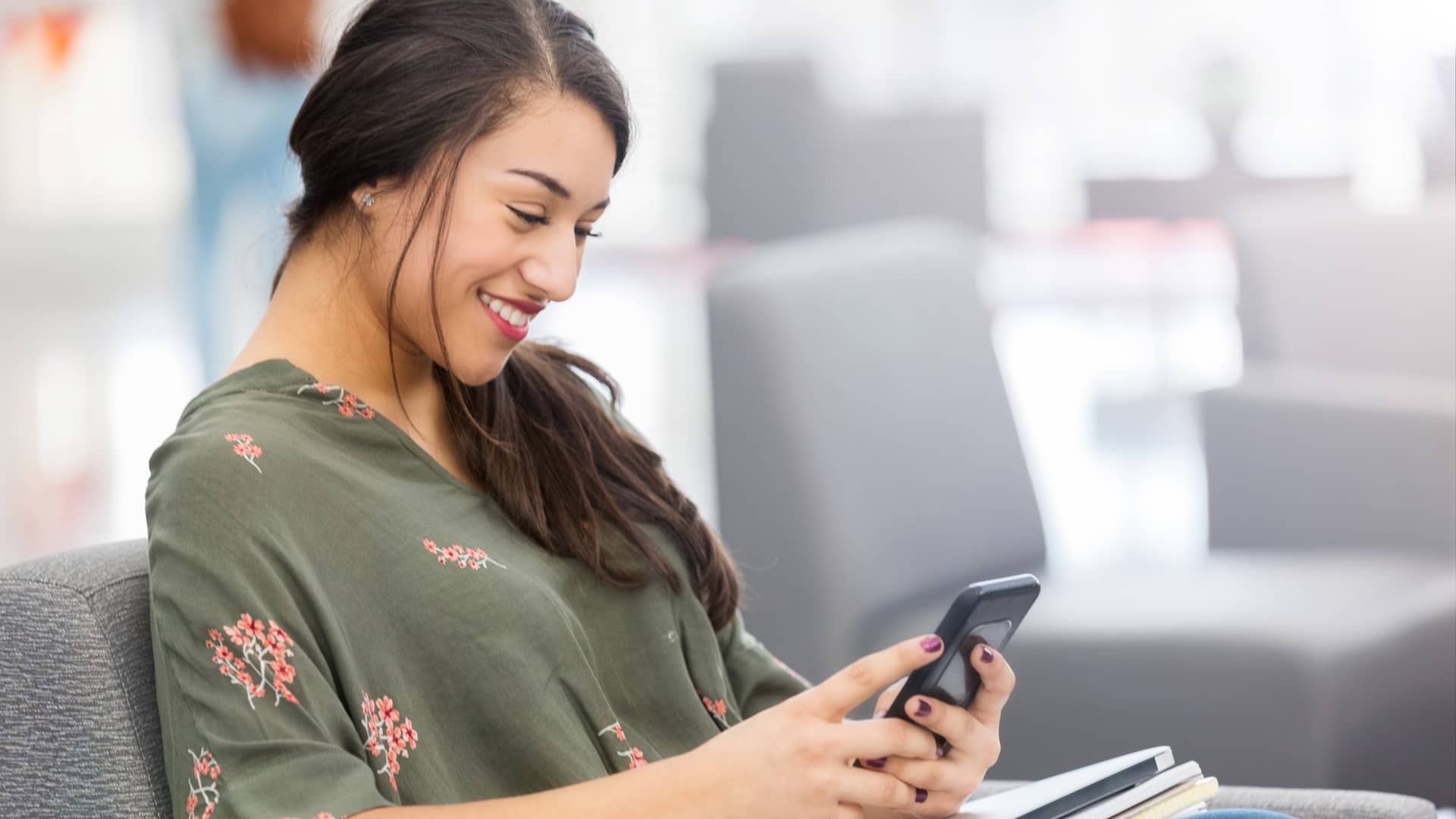 Mujer feliz viendo sus cuentas en su smartphone