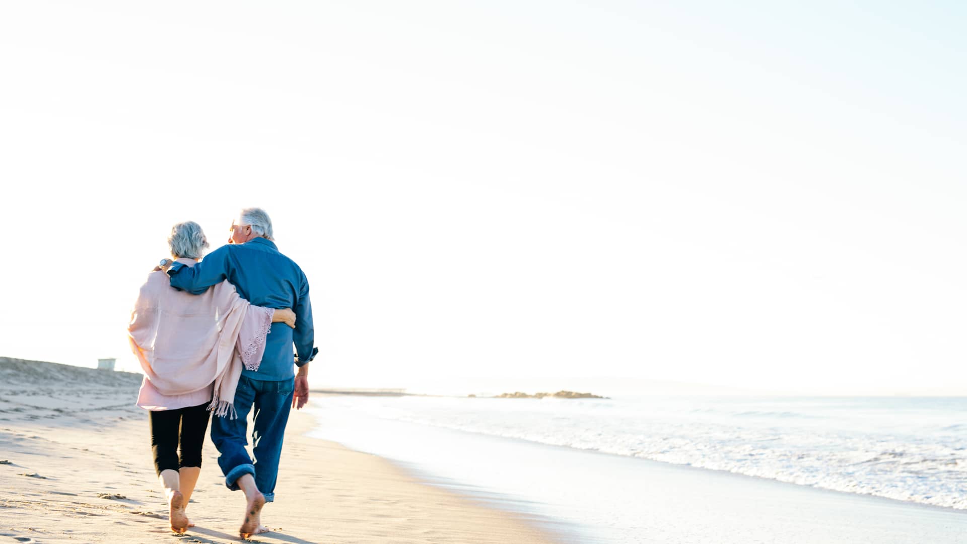 Jubilados de vacaciones disfrutando de paseo por la playa gracias a planes de pensiones deutsche bank