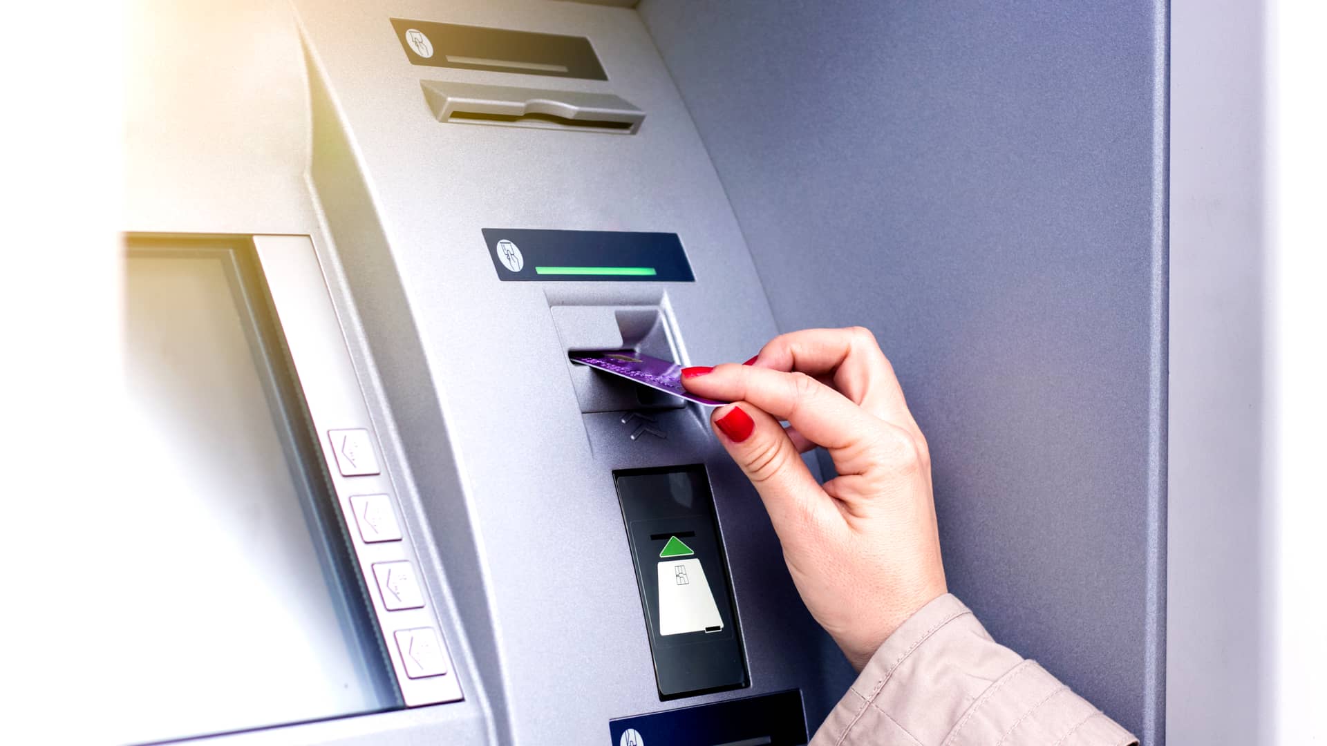 Mujer introduciendo tarjeta de crédito en cajero de oficina evo banco