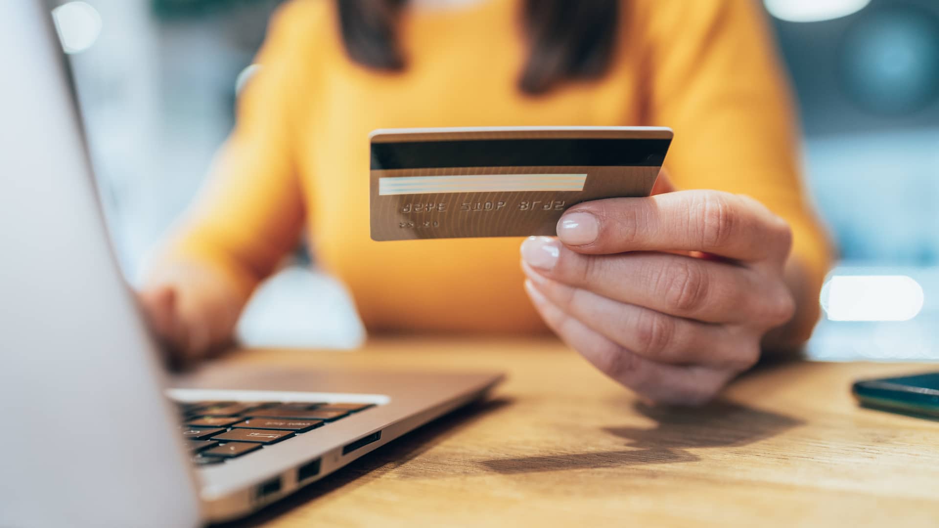 Mujer usando tarjeta de crédito de liberbank para realizar compra por internet con su laptop