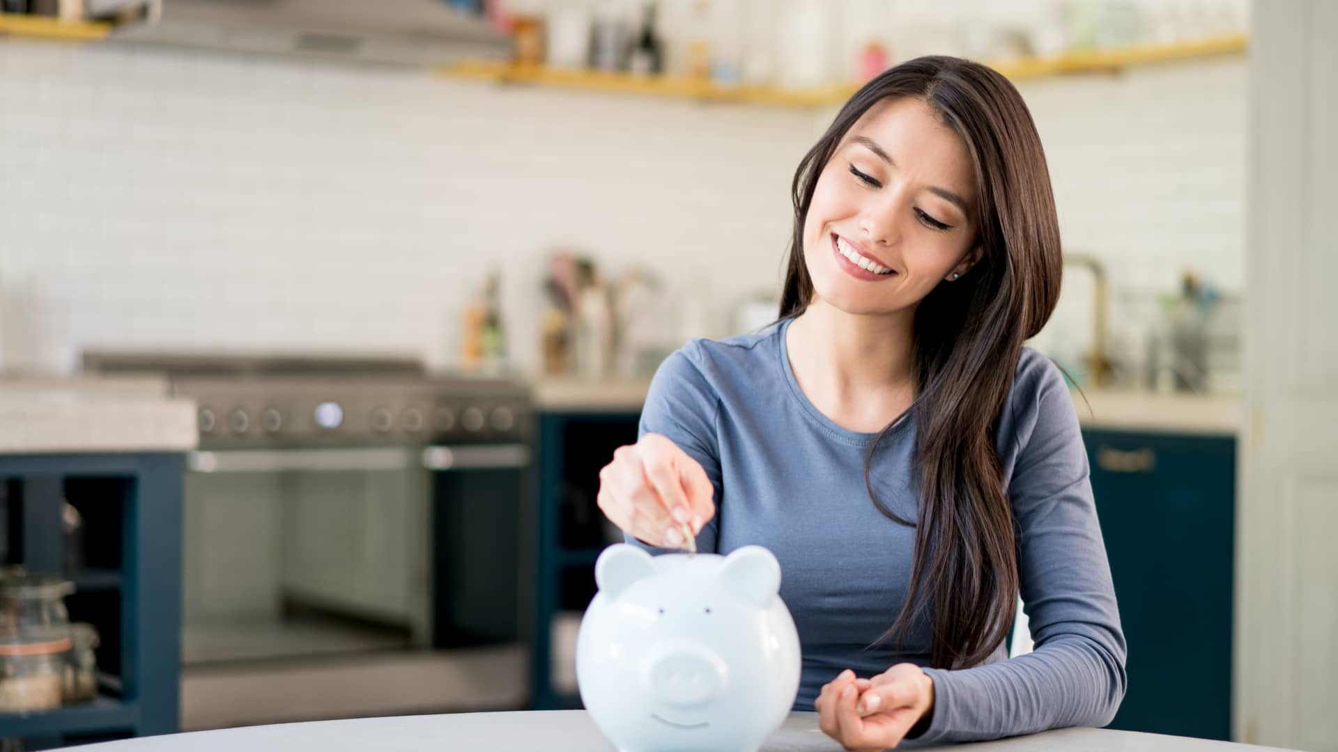 Mujer introduciendo moneda en hucha simboliza fondos inversión mediolanum
