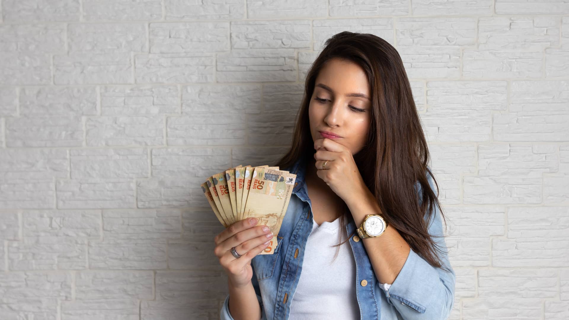 Mujer está mirando billetes en efectivo de su prestamo pensando en como actuar con él