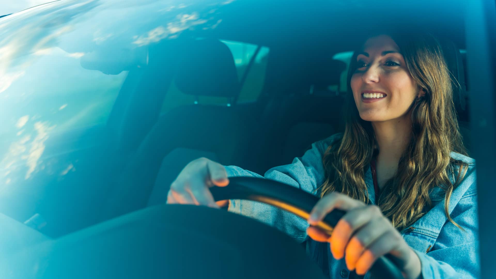 Mujer conduciendo su nuevo coche al que ha puesto un seguro con targo bank