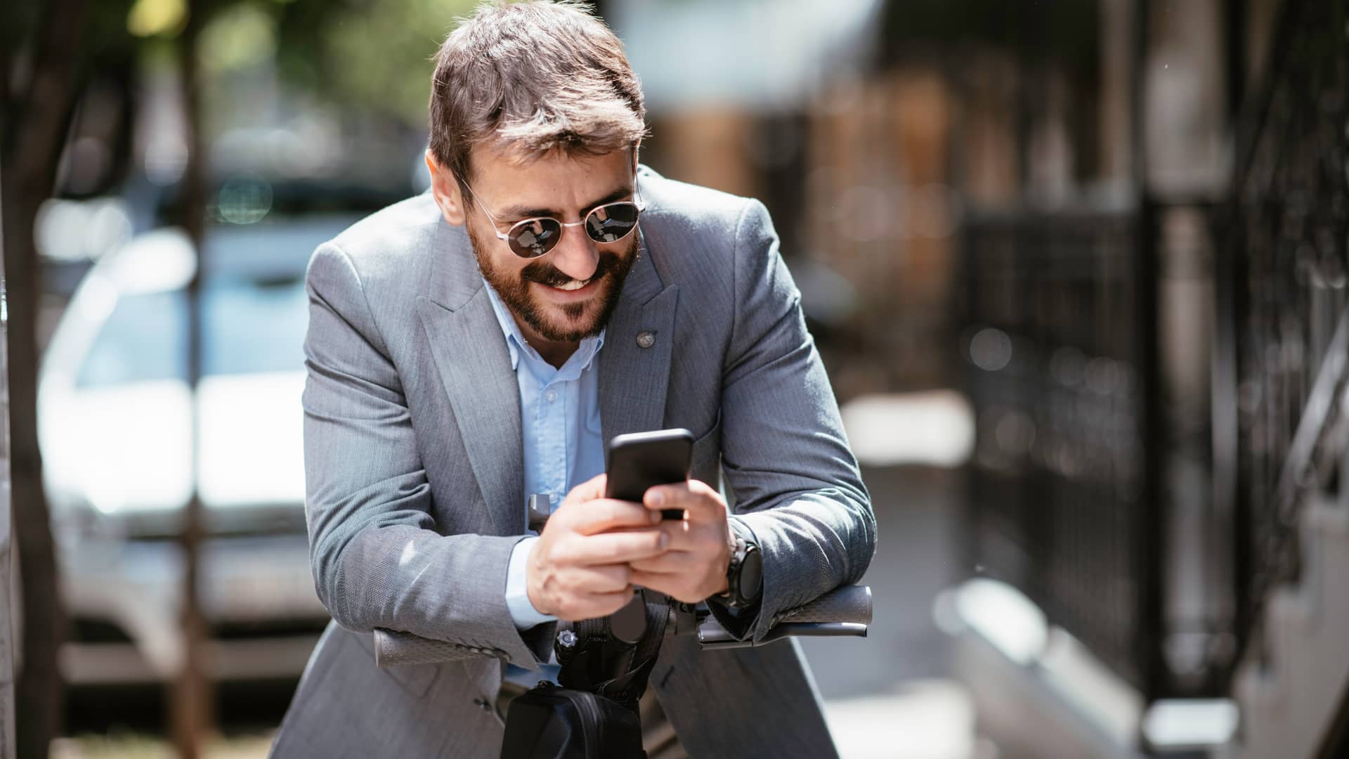 Hombre sonriente al ver el ratio de su inversión en su smartphone