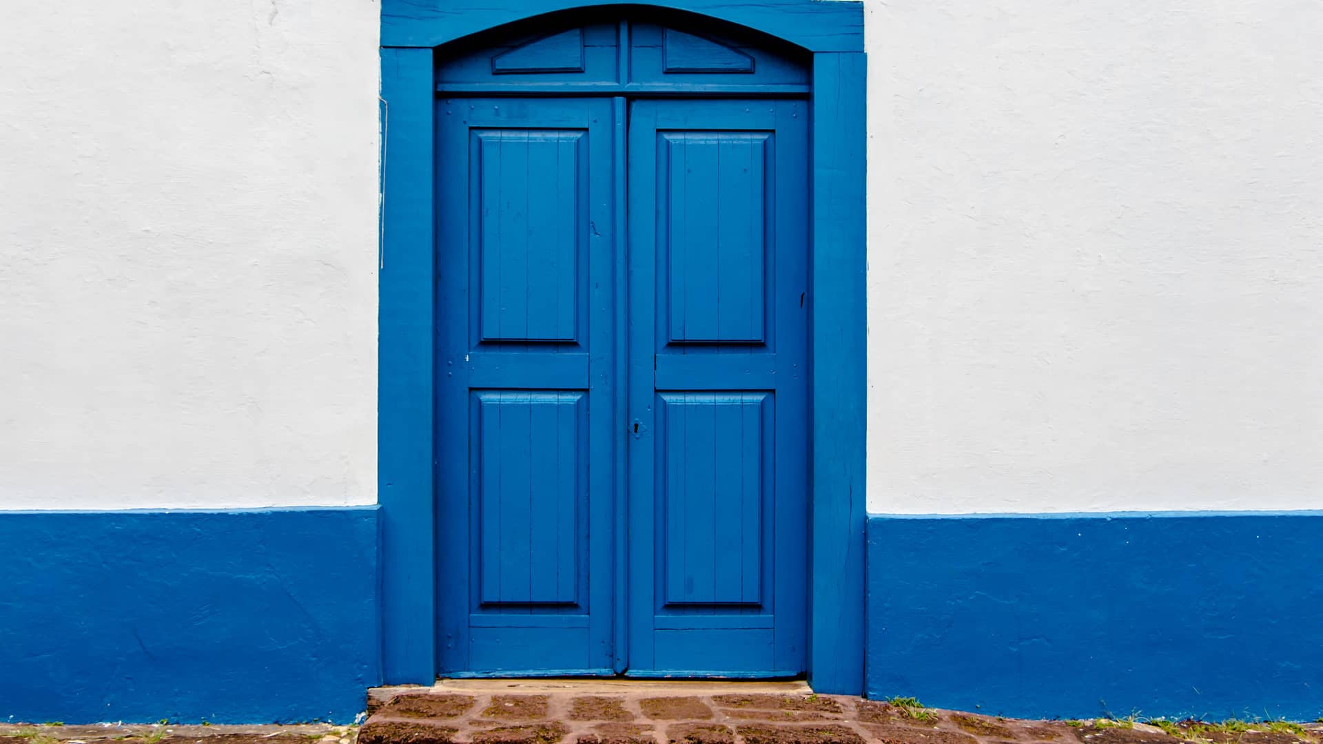 Puerta de una casa azul que tiene la clausula suelo con ibercaja