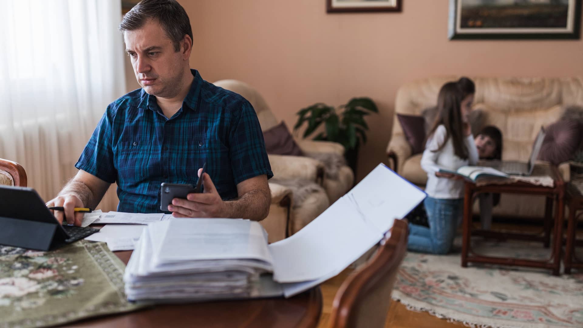 Hombre revisa las cuentas de una hipoteca que va a pedir mientras recopila toda la documentación necesaria para solicitarla