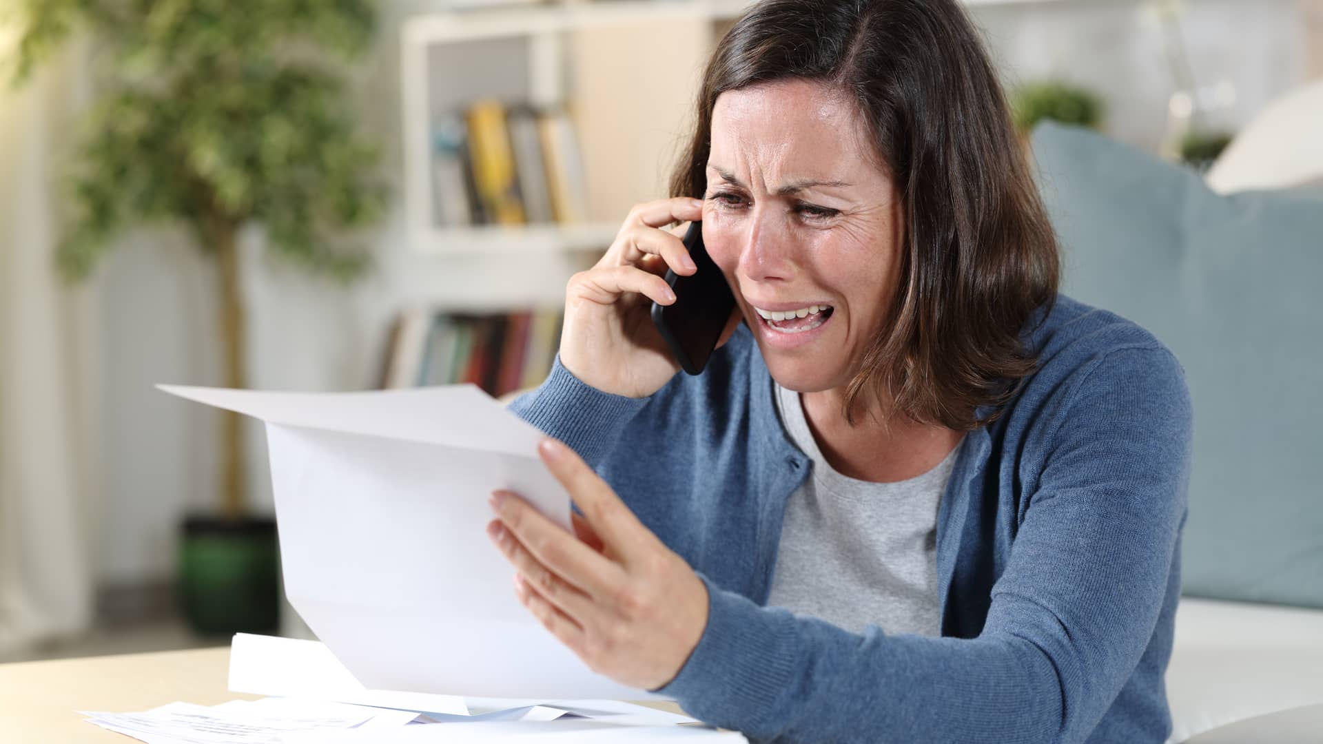 Mujer con papeles hablando por teléfono para reclamar gastos de hipoteca