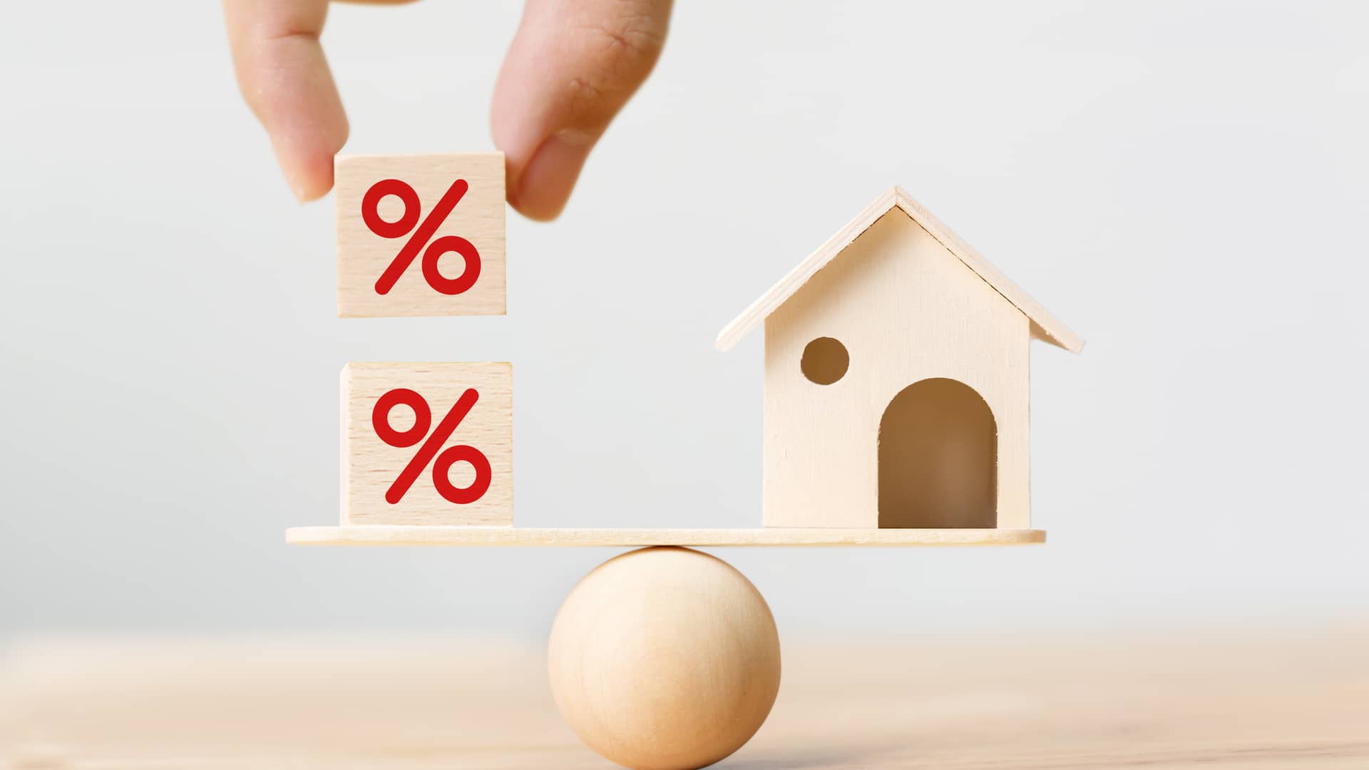 Concepto de una balanza con una casa y porcentajes que representa los interés del prestamo para un hogar